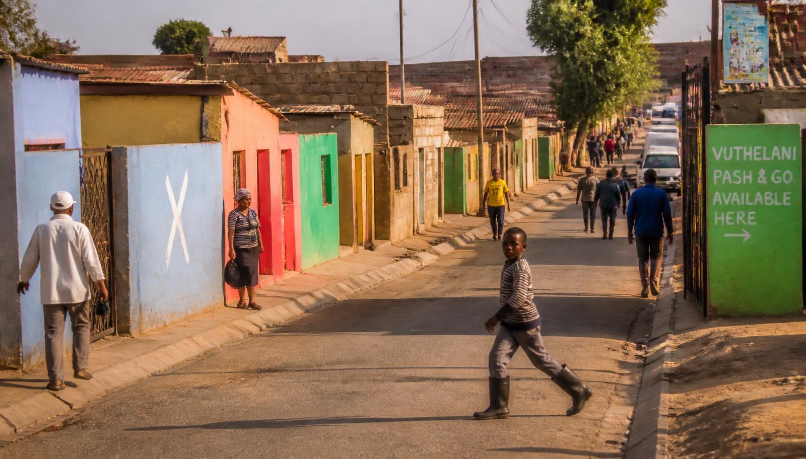 Street life in Soweto, Johannesburg, with colourful houses and people walking