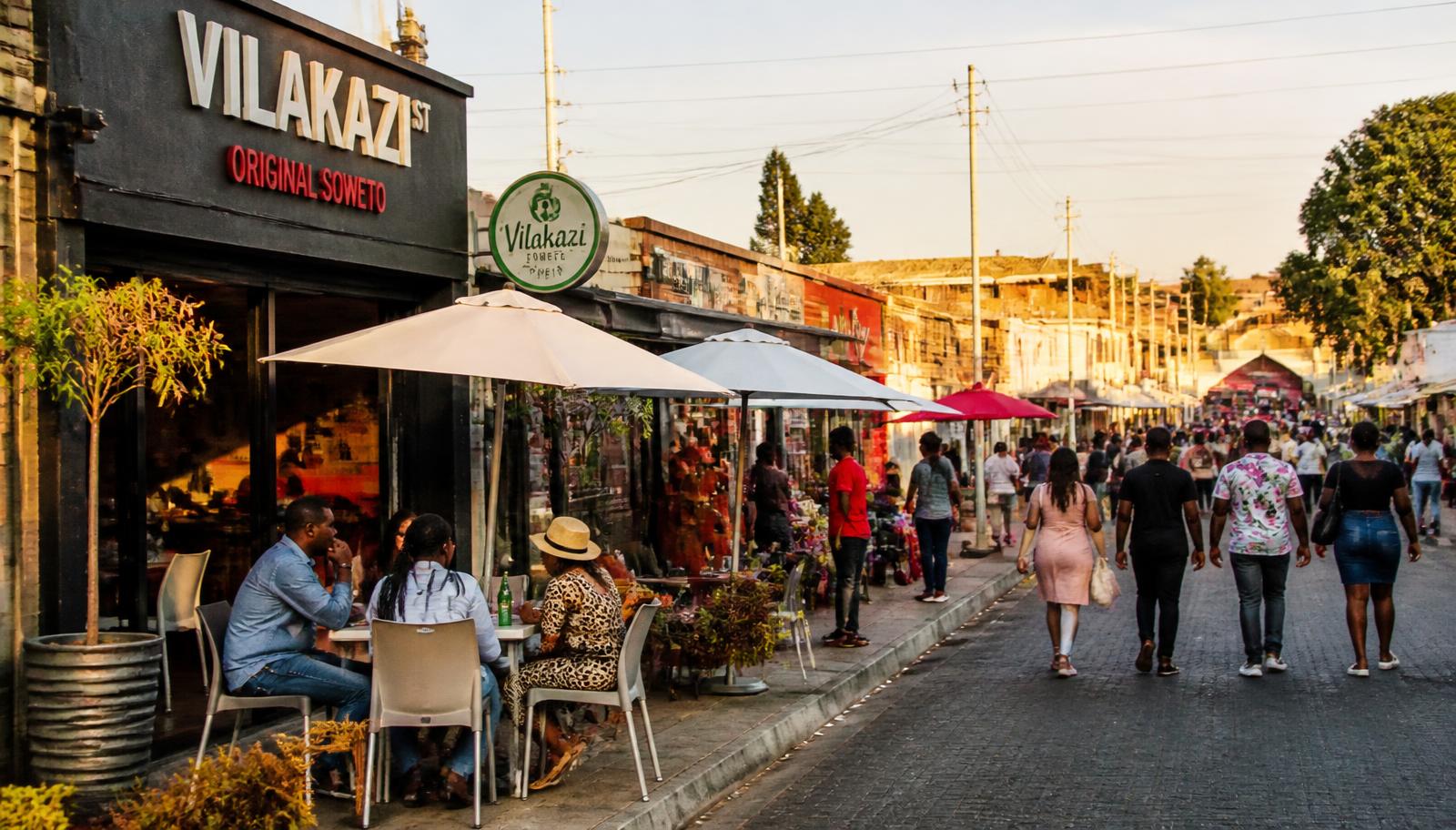 Vilakazi Street in Soweto with restaurants, vendors and people walking in the late afternoon